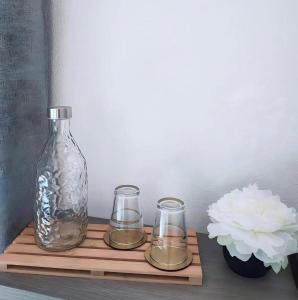 a wooden shelf with a glass bottle and two glasses at ELEGANCE GIBA Rooms in Giba
