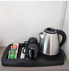 a tea kettle on a black tray on a table at ELEGANCE GIBA Rooms in Giba