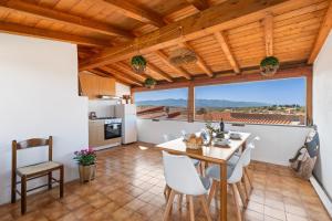 a kitchen and dining room with a table and chairs at Meravigliosa Terrazza Vista Mare in Tresnuraghes