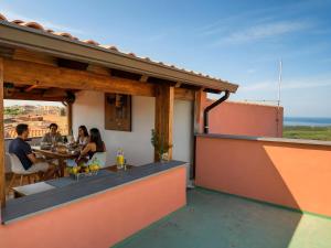 a group of people sitting at a table on a patio at Meravigliosa Terrazza Vista Mare in Tresnuraghes