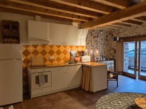 a kitchen with white cabinets and a yellow tile wall at Casa Sorianna in Montenegro de Cameros