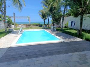 a swimming pool in a yard with palm trees at Kitnet com veranda in Conde