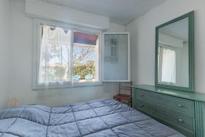 a bedroom with a bed and a dresser and a window at L'Echo des Vagues -Conciergerieland in Vieux-Boucau-les-Bains