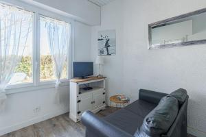 a living room with a couch and a television at L'Echo des Vagues -Conciergerieland in Vieux-Boucau-les-Bains