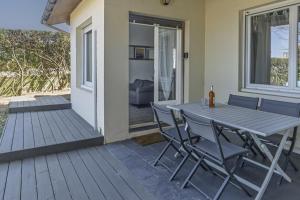 a wooden deck with a table and chairs on it at L'Echo des Vagues -Conciergerieland in Vieux-Boucau-les-Bains
