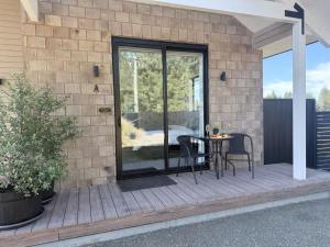 a patio with a table and chairs on a brick wall at Guesthouse A in Twizel