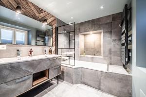 a bathroom with a tub and a sink at Chalet Design Terre De Sapins in Mont-Saxonnex