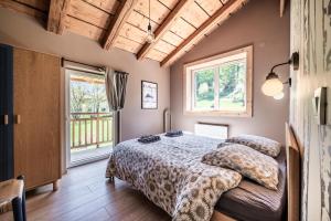 a bedroom with a bed and two windows at Chalet Design Terre De Sapins in Mont-Saxonnex