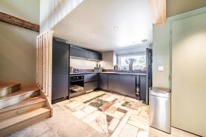 a kitchen with stainless steel appliances and a large window at Chalet Design Terre De Sapins in Mont-Saxonnex +26 photos