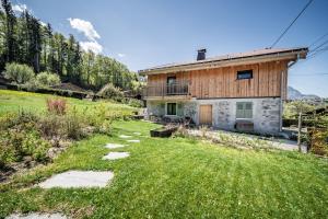 a house in the middle of a green field at Chalet Design Terre De Sapins in Mont-Saxonnex