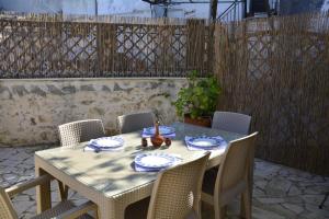 a wooden table with chairs and plates and a bowl on it at Roukouneli Traditional Stone House - Terrace & BBQ in Arménoi +34 photos