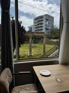 a table and a window with a view of a building at Forum View Apartments in Durrës