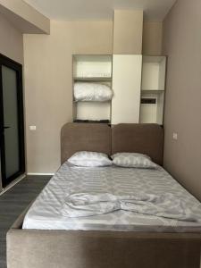 a bed in a room with two pillows on it at Forum View Apartments in Durrës