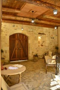 a room with a wooden door and a table and chairs at Roukouneli Traditional Stone House - Terrace & BBQ in Arménoi