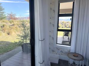 a door to a porch with a table and a view at Guesthouse A in Twizel +1 photo