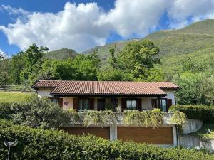 a house with a fence and mountains in the background at Casa Luciana in Mergozzo