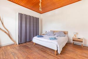 a bedroom with a bed and a wooden ceiling at Maison de vacances La Menou in Saint-Pierre-dʼOléron