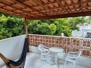 a patio with a table and chairs on a balcony at Kitnet com veranda in Conde