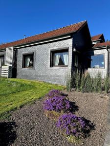 a house with purple flowers in front of it at Ferienhäuschen Gartenblick in Friedrichroda
