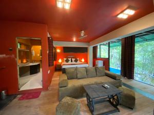 a living room with a couch and a kitchen at The Glenrock Wellness Nature Resort in Belihuloya