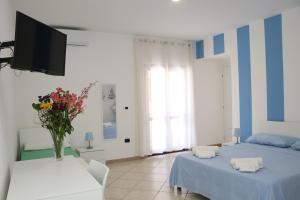 a bedroom with two beds and a tv on the wall at BlueBay room Calabria in Vibo Valentia Marina