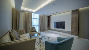 a living room with a couch and a tv at شقق فندقيه رسال in Ar Riyāḑ