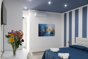 a blue and white bedroom with a bed and a vase of flowers at BlueBay room Calabria in Vibo Valentia Marina +50 photos
