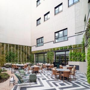 a patio with tables and chairs in front of a building at Urban Hive Madrid in Madrid
