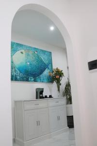 a white kitchen with a fish painting on the wall at BlueBay room Calabria in Vibo Valentia Marina