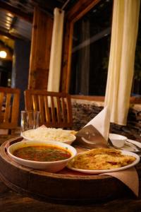 a table with two plates of food on a table at The Crystal Cabin in Jibhi