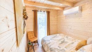 a small bedroom with a bed and a window at Cottage de luxe en bois in Longnes