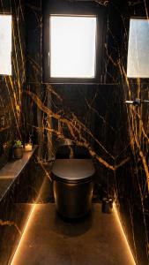 a bathroom with a toilet with a window and a tub at Cottage de luxe en bois in Longnes +8 photos