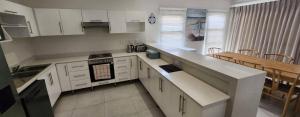 a kitchen with white cabinets and a counter top at Serena in Gueima