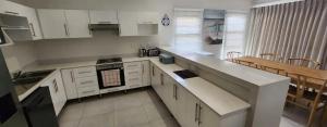 a kitchen with white cabinets and a counter top at Serena in Gueima