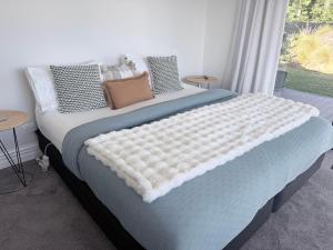 a bedroom with a large bed with pillows and a window at Guesthouse B in Twizel +3 photos