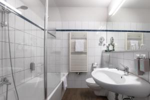 a white bathroom with a sink and a toilet at Hotel Engel in Hamburg +59 photos