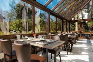 a restaurant with tables and chairs and windows at Hotel Engel in Hamburg