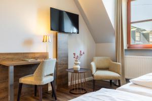 a hotel room with a desk and two chairs and a tv at Hotel Engel in Hamburg