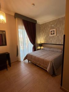 a bedroom with a bed and a large window at Hotel Hermitage in Qualiano +58 photos