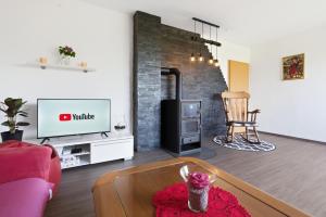 a living room with a couch and a tv at House Molnar in Kočevje
