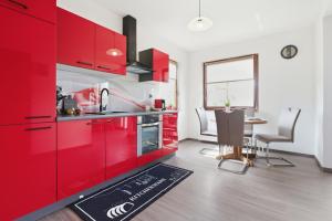 a kitchen with red cabinets and a dining table at House Molnar in Kočevje +6 photos