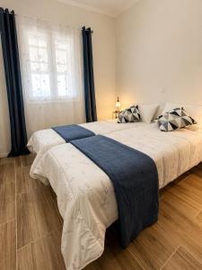 a bedroom with a large bed with pillows and a window at Casa Plati 1 - Modern Escape with Pool & Garden in Platí