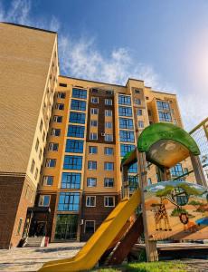 a yellow slide in front of a building at ЖК Альфараби in Kokshetau
