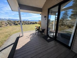 a porch of a house with a table and glass doors at Guesthouse B in Twizel