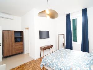 a bedroom with a bed and a desk and a television at Incoming Medina in Naples