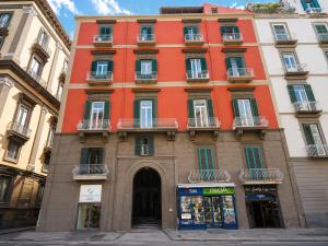 a tall orange building with windows on a street at Incoming Medina in Naples