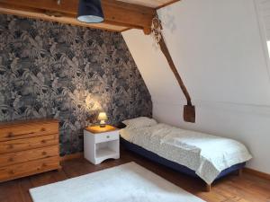 a bedroom with a bed and a dresser and a bed sidx sidx sidx sidx at Le Marronnier in Montchauvet