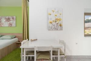 a bedroom with a white table and a bed and a window at Apartments Zeljko in Pag