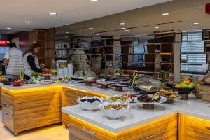 a buffet line with bowls of food in a restaurant at Lion City Hotel Ankara in Ankara