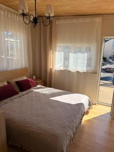 a bedroom with a large bed and a window at Malūno namai 2 in Palanga +24 photos